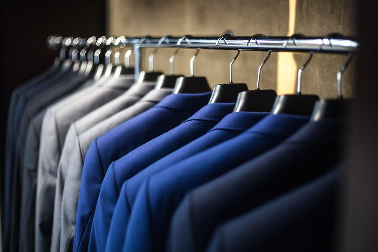 Home Close-up of neatly arranged suits in a wardrobe, showcasing fashion and organization.
